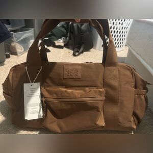 Beis sports duffle backpack in maple. NWT. Multiple pouches. Can fit on luggage.